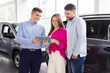 © Anastasiya - Salesman showing details on digital tablet to smiling couple in a car dealership. Friendly communication and technology-driven customer experience in showroom