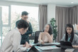 © ArLawKa - Group of business people discussing charts and graphs showing results of teamwork of colleagues working together at desks in office and discussing documents.
