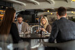 © Creative Light - Business colleagues using phones at a restaurant table during a meeting