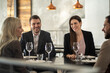 © Creative Light - Friends enjoying a meal together at a restaurant, smiling and laughing