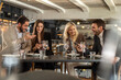 © Creative Light - Business colleagues sharing phones and laughing at a restaurant