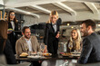 © Creative Light - Restaurant staff serving food to a group of happy customers at a table