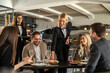 © Creative Light - Restaurant staff serving food to a group of happy customers at a table