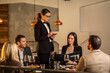 © Creative Light - Elegant restaurant scene with a server taking an order from a group of friends