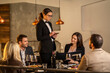 © Creative Light - Elegant restaurant scene with a server taking orders from a group of friends