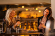 © Creative Light - Two women enjoying red wine and a meal at a restaurant