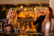 © Creative Light - Two women enjoying wine and a meal at a restaurant