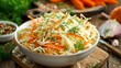 © RanaMuhammad - A bowl of coleslaw salad with shredded cabbage carrots and dill on a wooden board in soft lighting