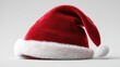 © Johannes - an image of a classic red santa claus hat on a clean white background the hat is made of red felt or velvet with a white fur trim and a white pom pom at the tip the hat is laid on its side showing