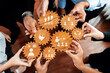 © InfiniteFlow - Hands unite around wooden gears, symbolizing collaboration and shared ideas in a modern business setting. This image showcases teamwork and strategy for success. Amity