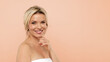 © Anastasiya - Portrait of cheerful attractive half-naked middle aged blonde woman smiling at camera, posing on beige studio background, demonstrating glowing perfect skin, copy space. Cosmetology concept. High