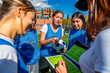 © unai - Women's soccer team analyzing strategy with coach on field