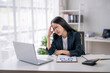© Wasana - Businesswoman experiencing stress at work desk