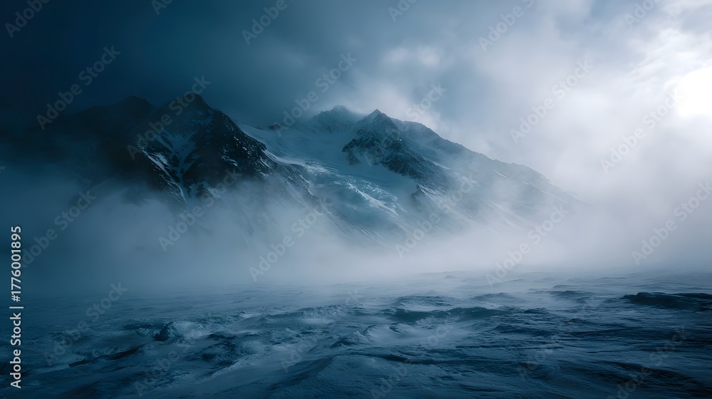 Dramatic snowy mountain peaks shrouded in dense fog and swirling mist ...