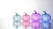 © Bijoy - Vibrant illuminated glass pumpkins on reflective white background