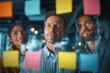 © ttonaorh - Group of young professionals collaborating during brainstorming session, using colorful sticky notes on glass wall in modern office.