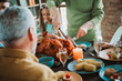 © deagreez - Funny family feast on Thanksgiving as big turkey takes center stage while relatives share laughter and love around a warm table