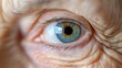 © Yuliia - Close-up of elderly person's bright blue eye with detailed iris and pupil, surrounded by natural skin wrinkles and texture. Perfect for healthcare or aging concepts.