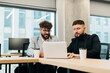 © dsheremeta - Businessmen collaborating, discussing project on laptop in office
