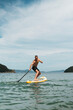 © Aboltin - Man practices balance on SUP board during summer vacation. Water activity that combines sport, relaxation, and connection with nature.