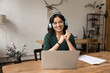 © fizkes - Happy young woman wearing headphones communicate online via notebook