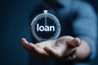 © sornram - A hand holding a stopwatch with the word loan, symbolizing time management in financing and loans.