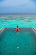 © Kyrenian - Tranquil closeup calm sea water waves with palm trees. Man tourist posing, Tropical island beach landscape exotic shore coast. Summer vacation, holiday amazing nature. Relax paradise, Maldives.