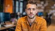 © Valentyna Prudnikova - Professional young creative sitting in modern office workspace wearing vibrant yellow denim jacket with confident expression and blurred background