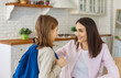 © Studio Romantic - Happy mother and child ready in morning for first day at school. Smiling parent and son wearing blue backpack standing in home kitchen to say goodbye with support and love before school lessons
