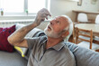 © Jelena Stanojkovic - Eye drops, senior man with medical, healthcare and wellness pharmaceuticals. Senior male with dry eyes and medicine for vision solution and allergy product.