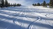 © Md Saiful - Ski slope with groomed corduroy texture and fresh ski tracks under a bright blue sky snow winter