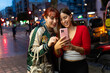 © Alfonso Soler - Teenage girls smiling while using smartphone apps shopping