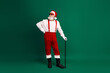© deagreez - Santa Claus dressed in festive attire standing with a cane on a green background, portraying a cheerful holiday spirit
