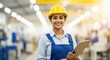 © Vasiliy - Confident female factory worker in a yellow hard hat smiling at the camera. Portrait of a young Indian industrial engineer holding a clipboard in a manufacturing plant
