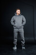 © DSMT - Stylish young man modeling gray sportswear in a minimalist studio setting during a photoshoot