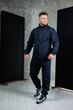© DSMT - Fashionable man showcasing modern athletic wear in a stylish indoor studio setting with contemporary elements