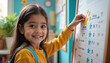 © AlenaSi - Little girl sticking reward star on progress chart in classroom. Reward star motivates child during elementary school and early education activities.
