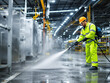 © gankevstock - Skilled worker in safety gear pressure washing a modern factory floor for cleanliness
