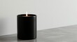 © Image - A minimalistic shot of a burning candle in a black container on a concrete surface.