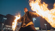 © MarGa - Middle-aged Hispanic man performs as Flambeaux torchbearer with flaming torches. Dramatic fire dancer in city at night. Mardi Gras festival and cultural tradition concept