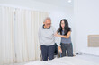 © Creativa Images - Young Female Caregiver Assisting Elderly Man with Mobility and Transfer to Bed