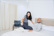 © Creativa Images - Young Female Caregiver Helping Elderly Man Lie Down in Bed with Gentle Assistance
