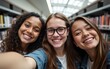 © li - POV selfie photo of multiethnic group of students smiling at camera in school library. High quality