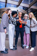 © alfons - Group of professional businesswomen looking at digital tablet outdoors near modern office. Teamwork, communication, leadership, strategy and collaboration concept in corporate environment.Vertical