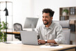 © New Africa - Man working on laptop at table in office