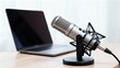 © Worldwide - Professional microphone beside a laptop on a desk, ideal for recording or podcasting.