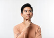 © isolatedpng - Portrait of an Asian man thoughtfully looking upward, contemplating a decision, on a white background.