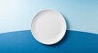 © Cahya - A white plate set on a blue and light blue background, ready for food