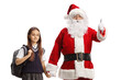 © Ljupco Smokovski - Santa claus gesturing a thumb up sign and holding hands with a girl in a school uniform