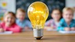 © Robert Kneschke - Light bulb glowing brightly in classroom, children blurred in background, symbolizing idea, innovation, education, and inspiration, concept of learning and creativity, school setting